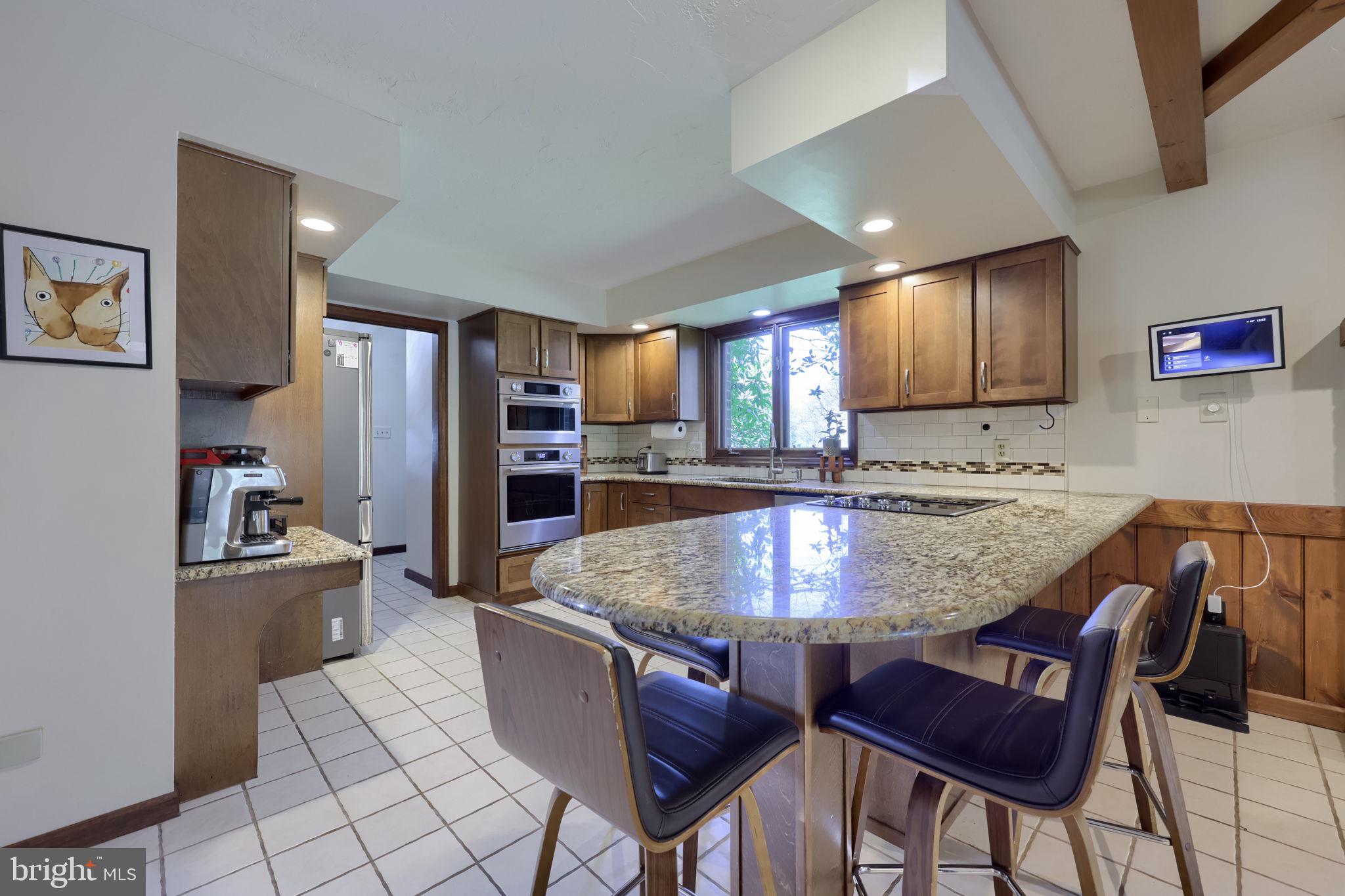 2211 Rocky Ridge Court York, PA 17406 - Photo 14 of 48 a kitchen with stainless steel appliances granite countertop a stove a sink a dining table and chairs