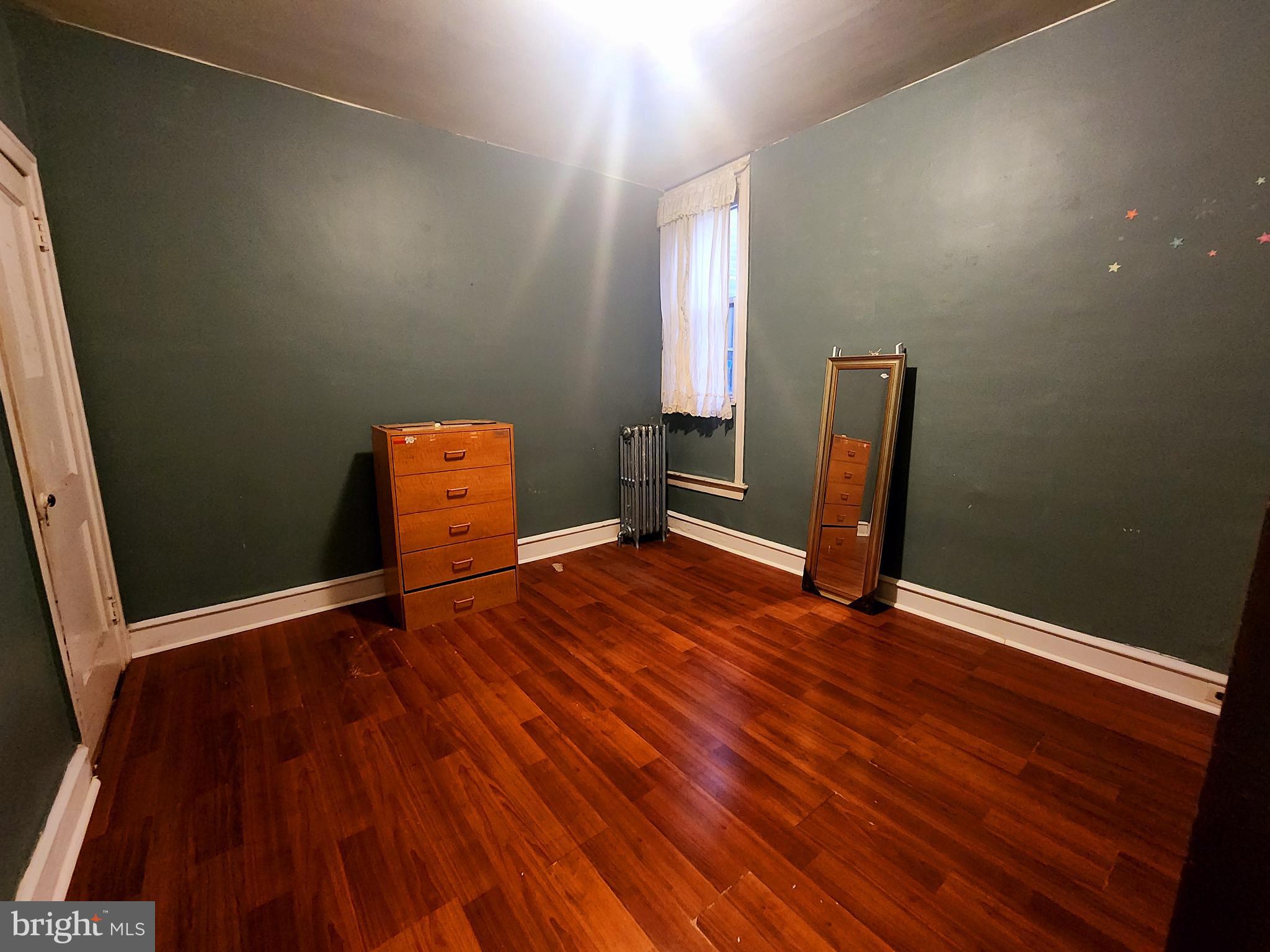 532 Marwood Road Philadelphia, PA 19120 - Photo 6 of 9 an empty room with wooden floor and chair