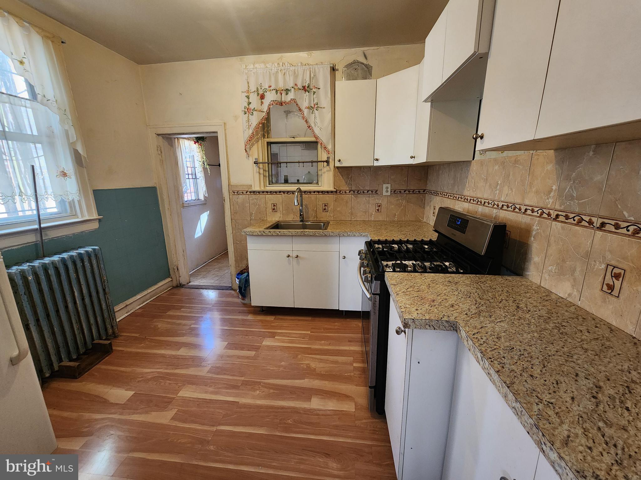 532 Marwood Road Philadelphia, PA 19120 - Photo 8 of 9 a kitchen with granite countertop a sink and a stove top oven