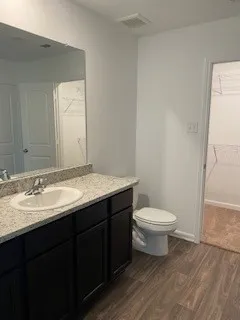 a bathroom with a granite countertop sink toilet and a mirror