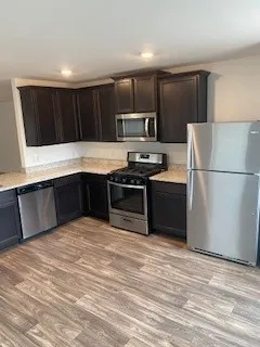 a kitchen with stainless steel appliances granite countertop a sink stove and refrigerator