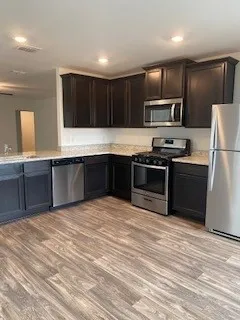 a large kitchen with cabinets and stainless steel appliances