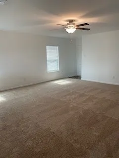 a view of an empty room with a chandelier fan