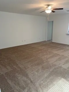 an empty room with a chandelier fan