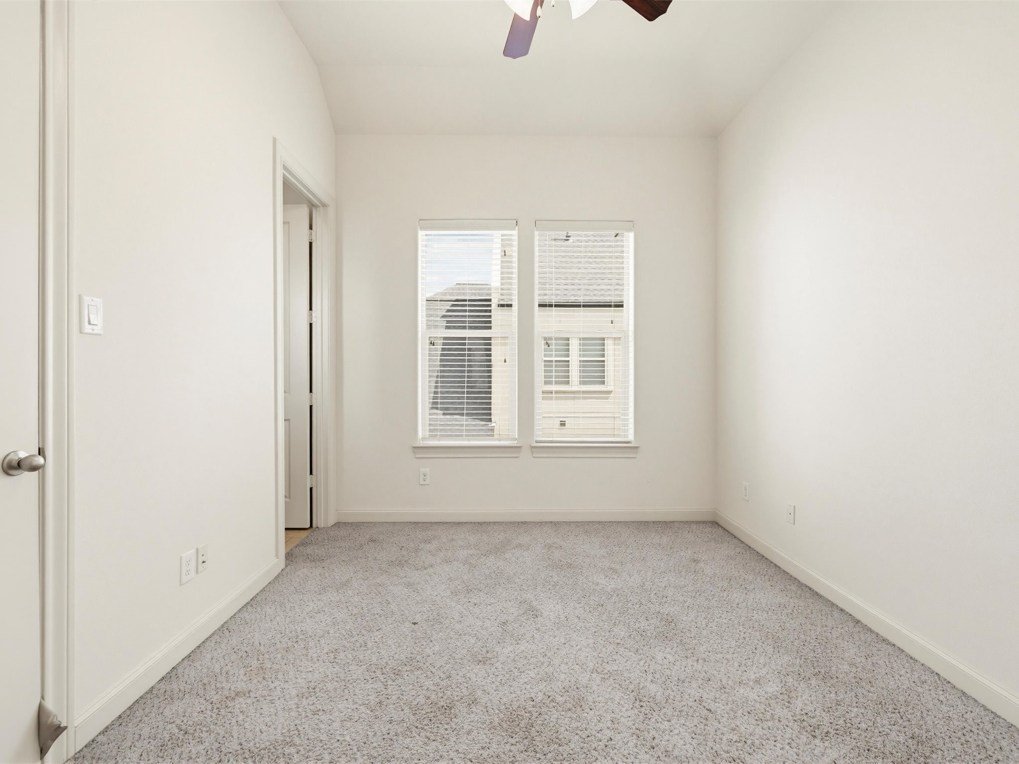 9427 London Bridge Station Houston, TX 77045 - Photo 19 of 30 A bright, empty room with neutral walls and carpet, featuring two windows for natural light. Ideal for a bedroom or office space.