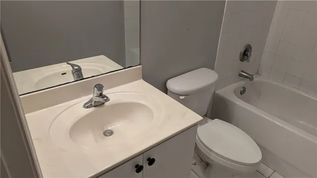 a bathroom with a sink and mirror with toilet