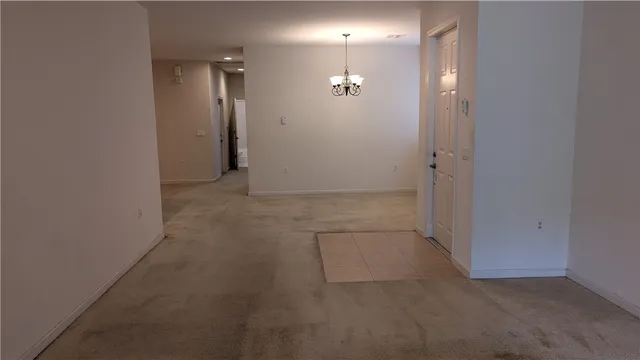 an empty room with white walls and mirror