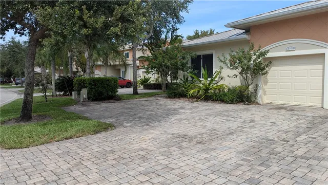 a view of a house with a yard and potted plants
