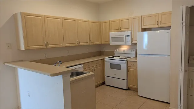 a kitchen with white cabinets and white appliances