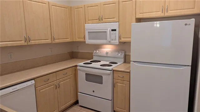 a white refrigerator freezer and a stove sitting inside of a kitchen