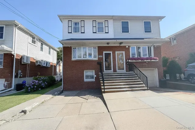 a view of a brick house with many windows and plants