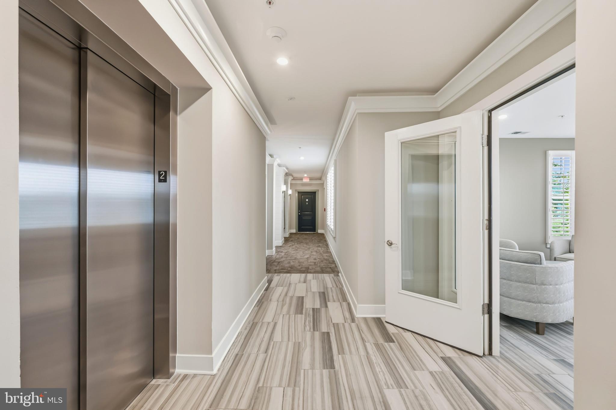 190 Harrier Way, Unit 24 Chester, MD 21619 - Photo 12 of 78 a view of a hallway with wooden floor and glass door