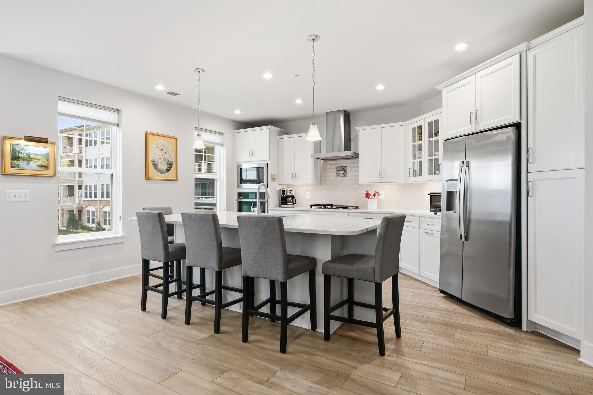 190 Harrier Way, Unit 24 Chester, MD 21619 - Photo 21 of 78 a kitchen with stainless steel appliances kitchen island granite countertop a dining table chairs refrigerator and sink