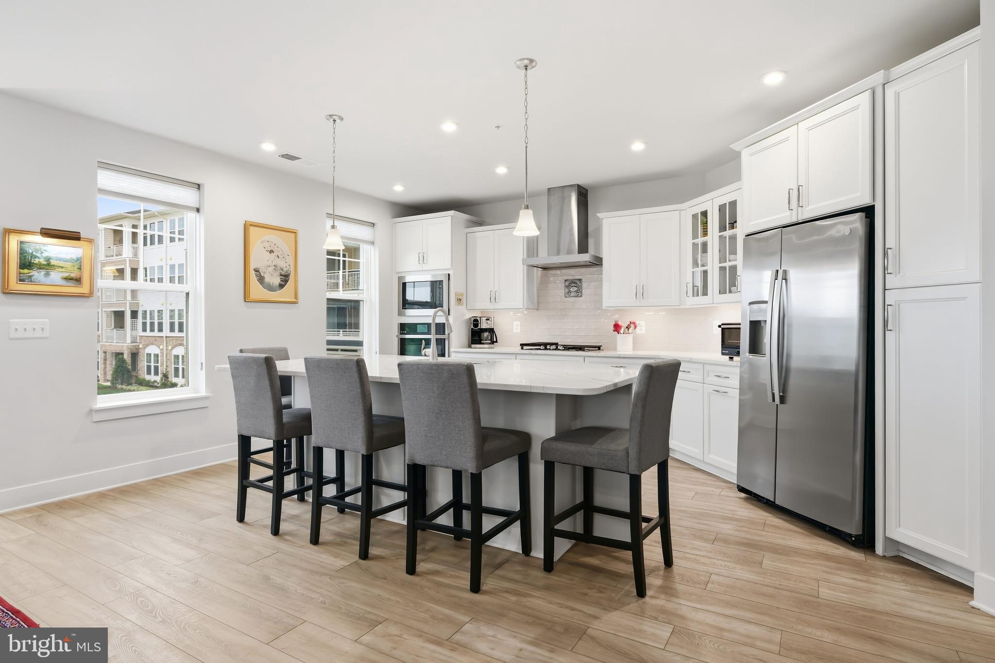 190 Harrier Way, Unit 24 Chester, MD 21619 - Photo 23 of 78 a kitchen with stainless steel appliances kitchen island granite countertop a dining table chairs refrigerator and sink