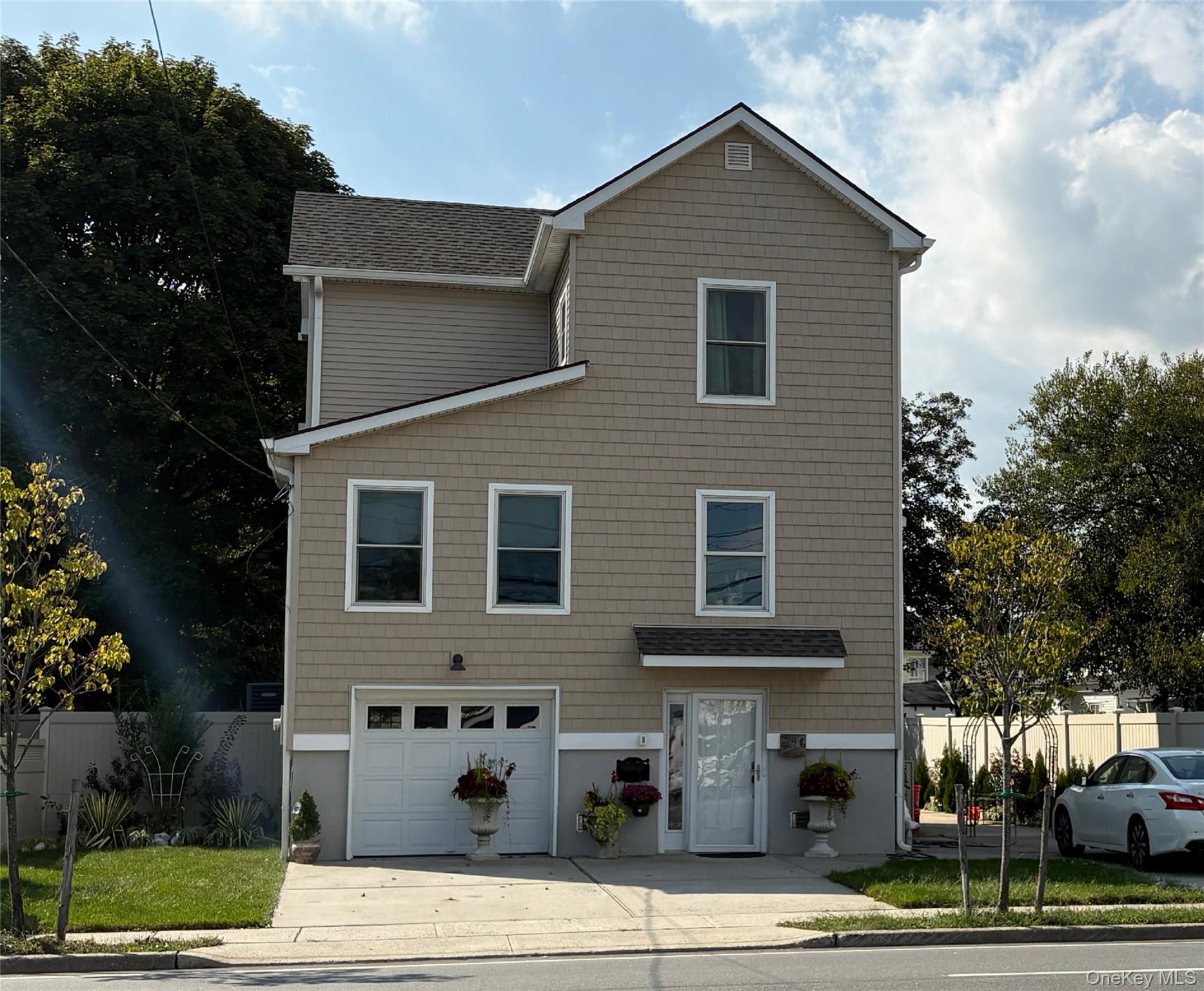 a front view of a house with garage and trees