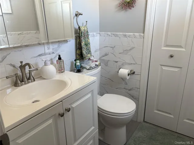 a bathroom with a granite countertop toilet sink and mirror