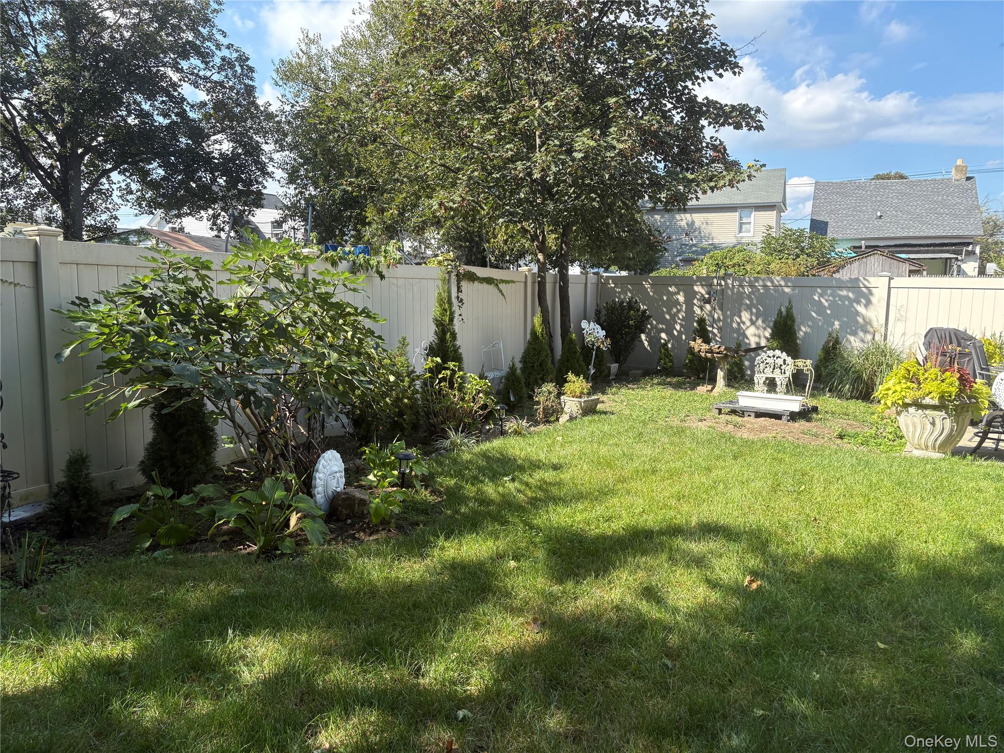 346 South Main Street Freeport, NY 11520 - Photo 31 of 33 a backyard of a house with table and chairs plants and large tree
