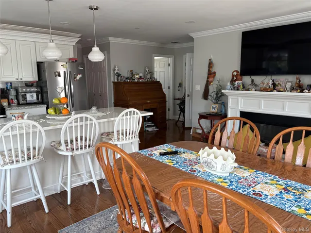a dining room with furniture a flat screen tv and a chandelier