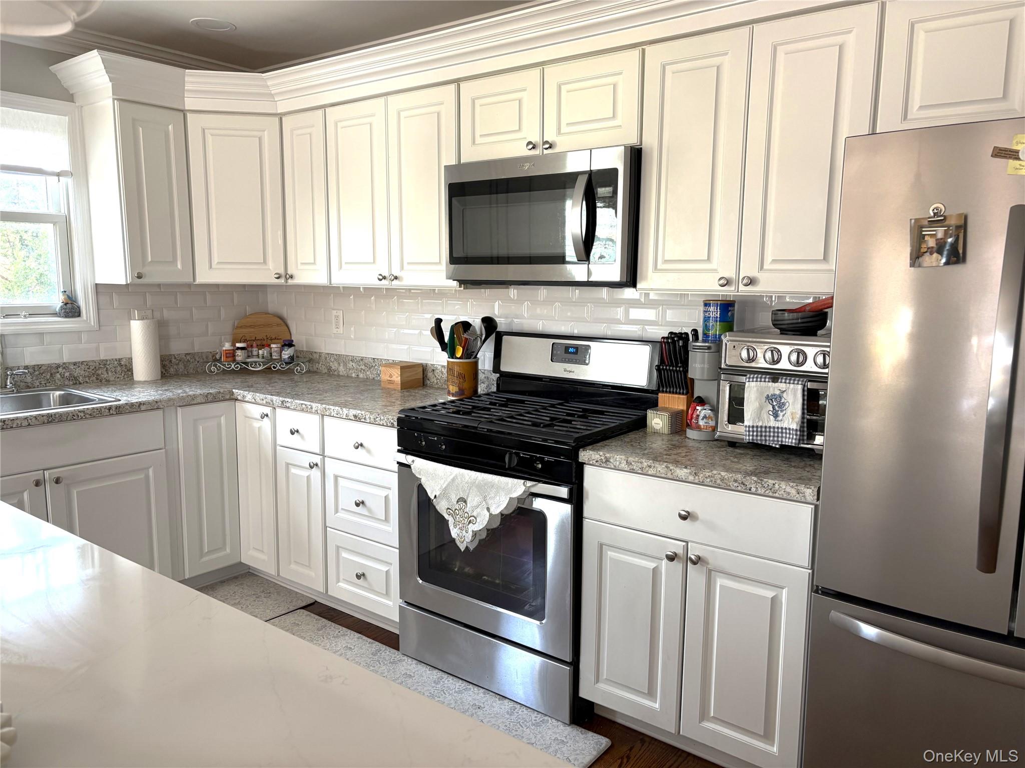 346 South Main Street Freeport, NY 11520 - Photo 7 of 33 a kitchen with white cabinets and appliances
