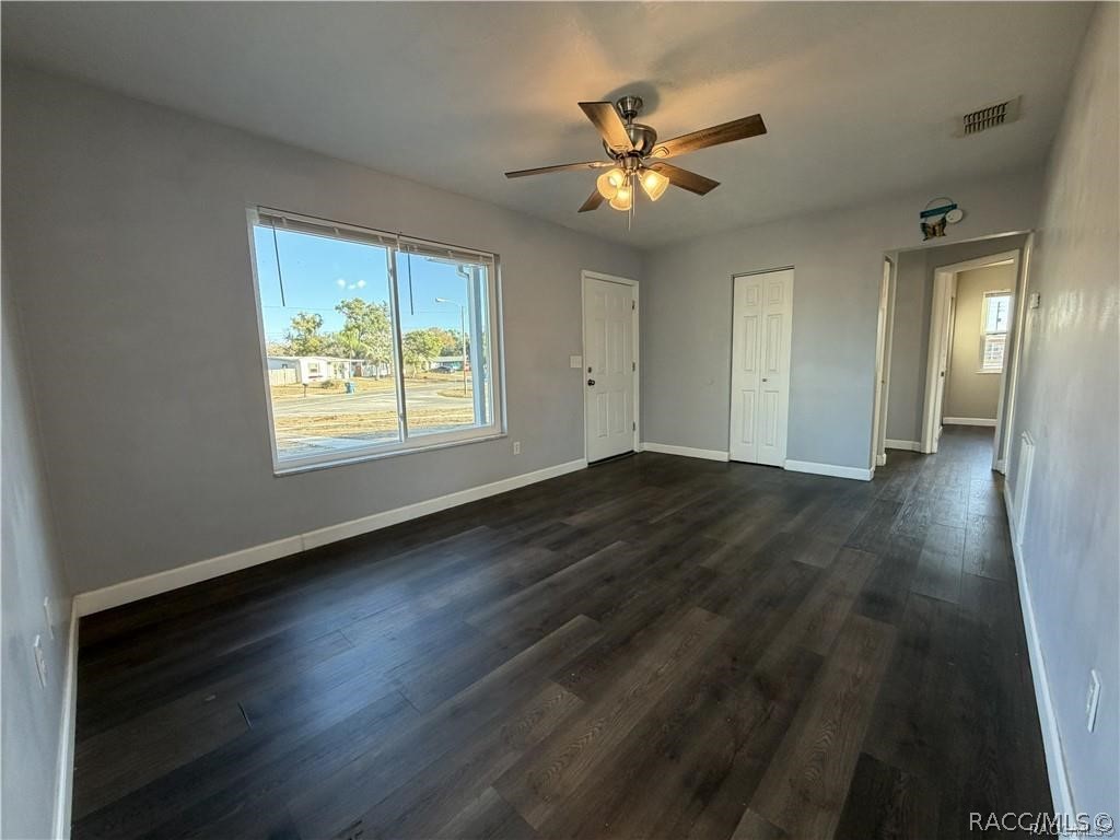 405 Copperfield Road Spring Hill, FL 34606 - Photo 7 of 25 a view of an empty room with wooden floor and a window