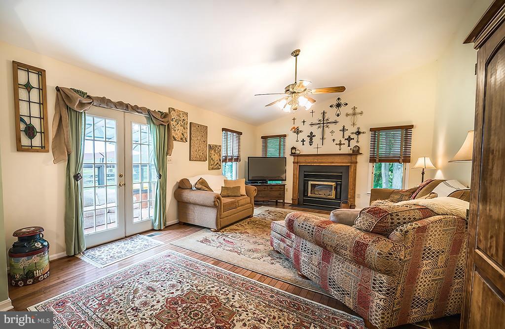 216 Serene Road Friendship, MD 20758 - Photo 17 of 29 a living room with furniture a fireplace and a chandelier