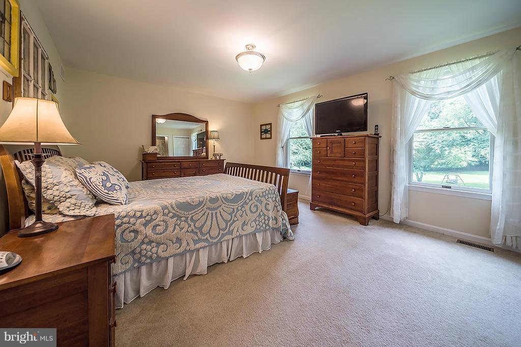 216 Serene Road Friendship, MD 20758 - Photo 19 of 29 a bedroom with a bed and a flat tv screen on dresser