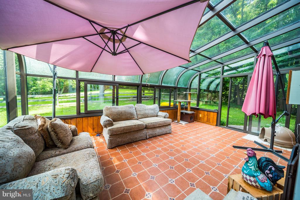 216 Serene Road Friendship, MD 20758 - Photo 25 of 29 a patio with patio a table and chairs under an umbrella