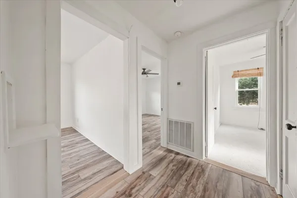 a view of a hallway with wooden floor and closet