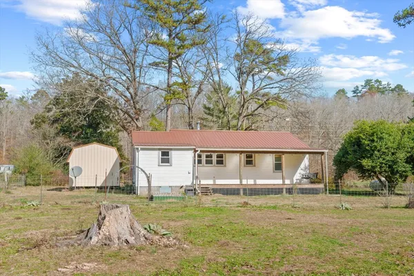 a view of a house with backyard and trees