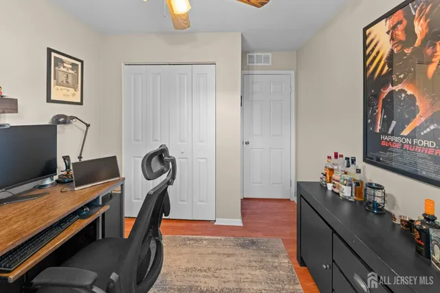 a view of a workspace with furniture and a window