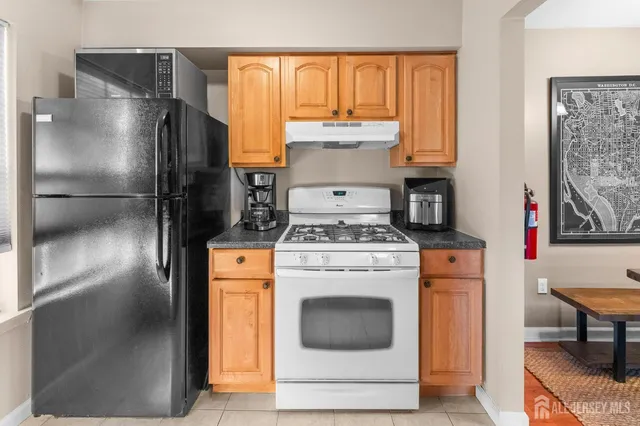 a kitchen with a refrigerator sink and cabinets