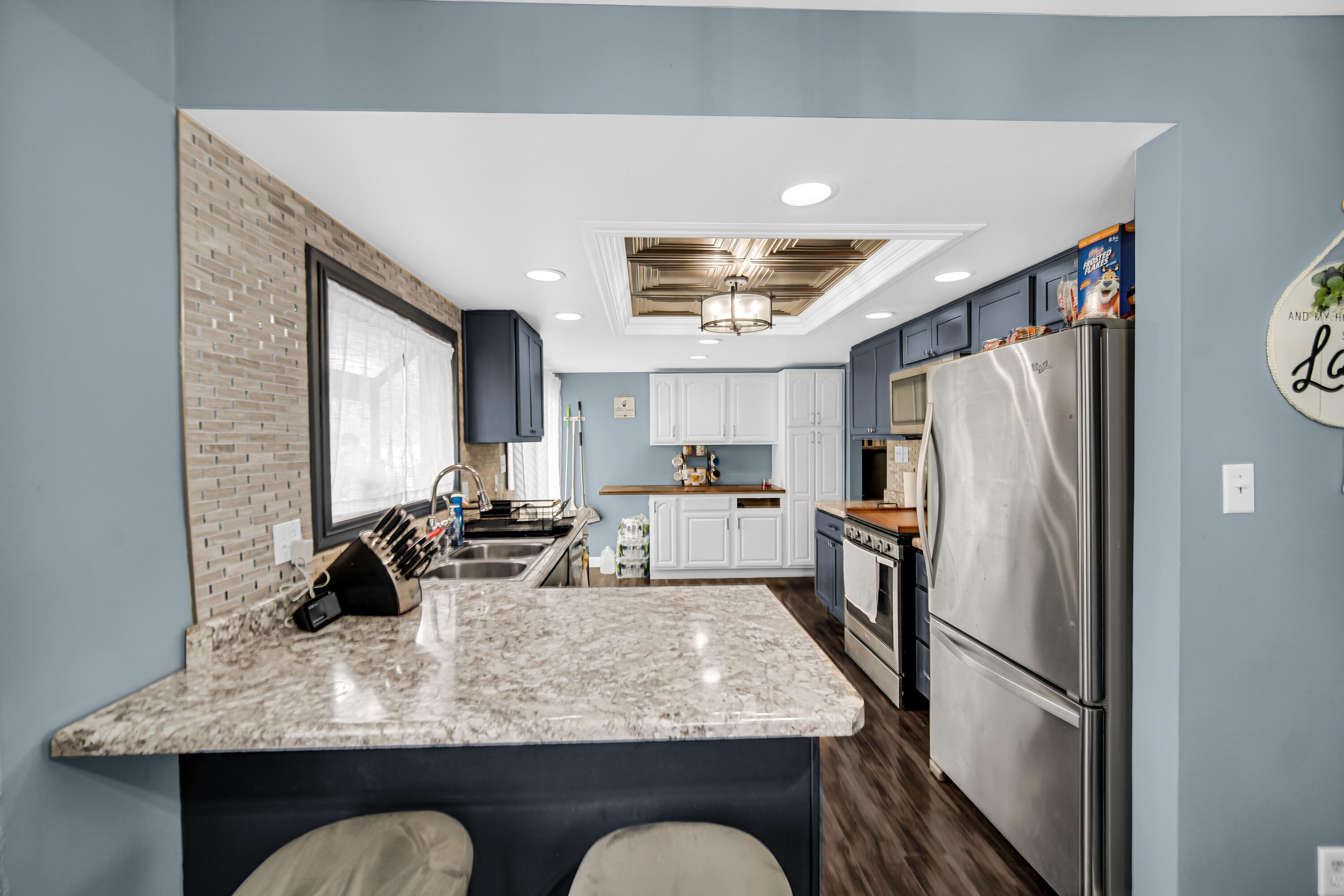 9017 Mathews Street Crown Point, IN 46307 - Photo 8 of 20 a kitchen with stainless steel appliances granite countertop a refrigerator a stove a sink dishwasher and white cabinets with wooden floor