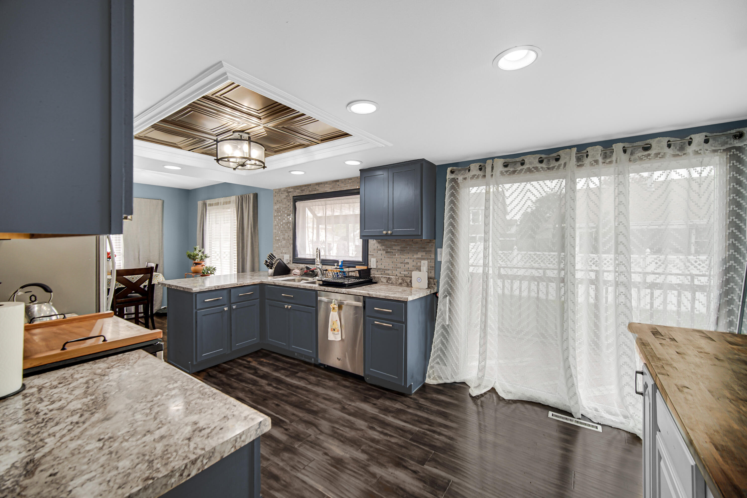 9017 Mathews Street Crown Point, IN 46307 - Photo 10 of 20 a large kitchen with kitchen island a large window a sink and stainless steel appliances