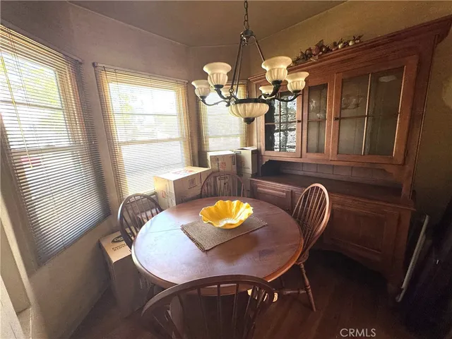 a bed sitting in a bedroom next to a window with pc on the table and a large mirror