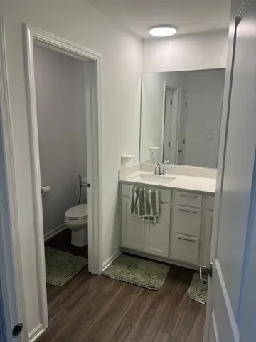 a spacious bathroom with a granite countertop sink toilet and mirror