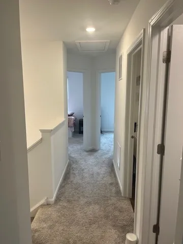 a view of a hallway with wooden shelves