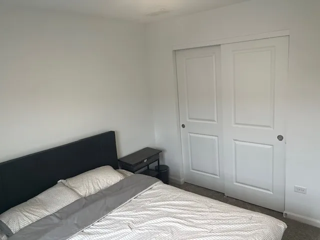a bedroom with a bed and a cabinet
