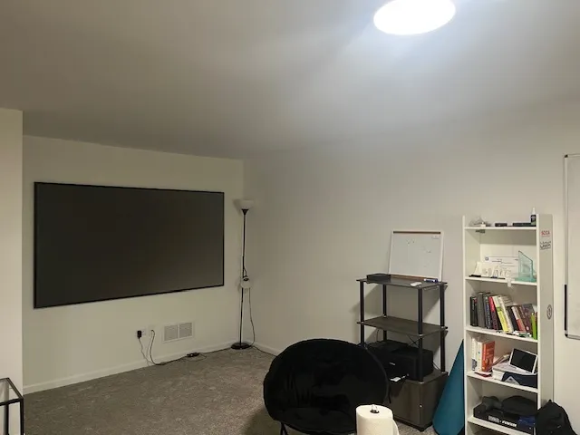 a living room with a flat screen tv and a lamp