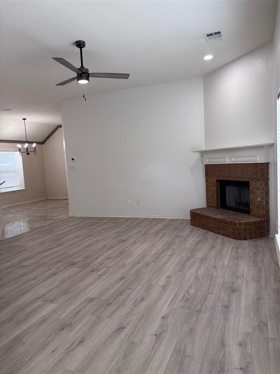 1348 Riley Drive Carrollton, TX 75007 - Photo 4 of 11 an empty room with wooden floor fireplace and windows