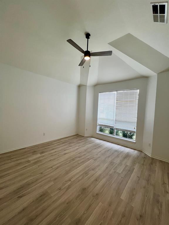 1348 Riley Drive Carrollton, TX 75007 - Photo 7 of 11 an empty room with wooden floor ceiling fan and windows