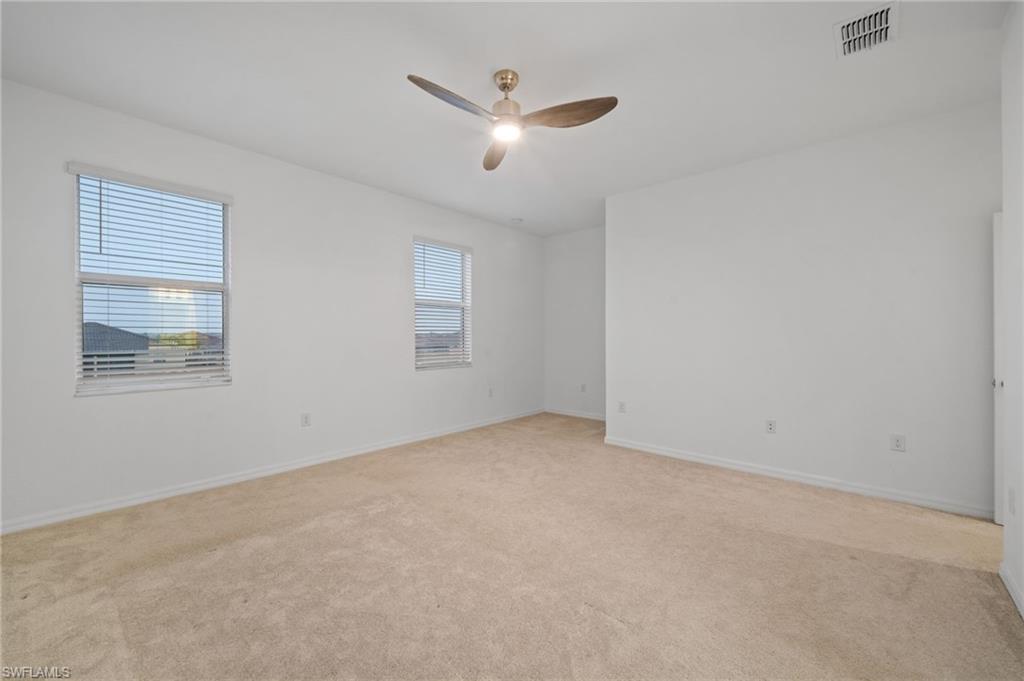 2878 Blossom Way Naples, FL 34120 - Photo 19 of 40 an empty room with ceiling fan and windows