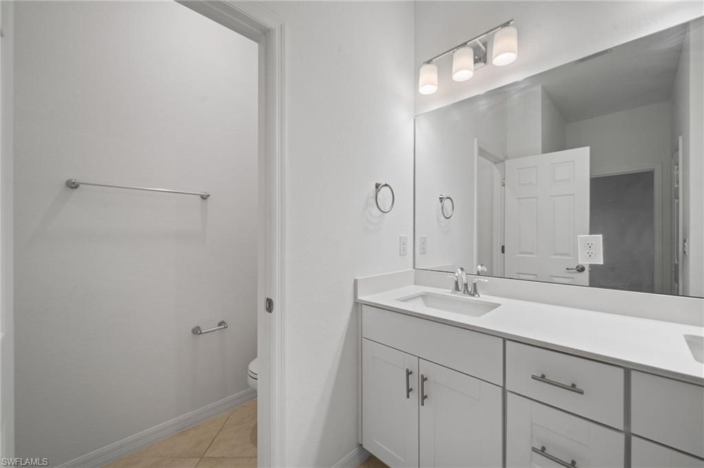 2878 Blossom Way Naples, FL 34120 - Photo 21 of 40 a bathroom with a sink and a mirror