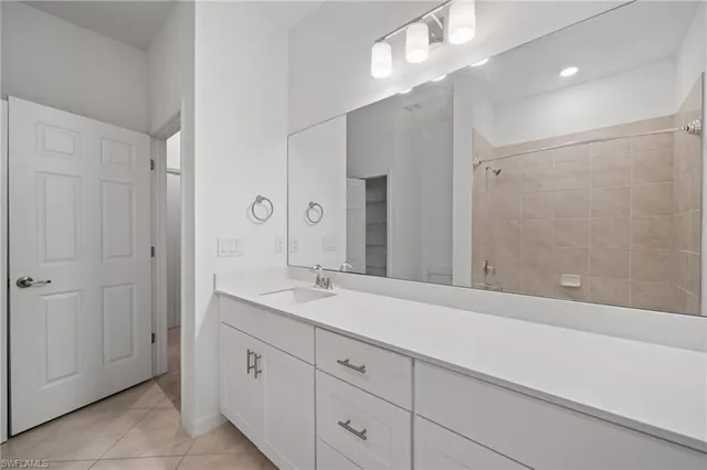 a spacious bathroom with a shower sink and mirror