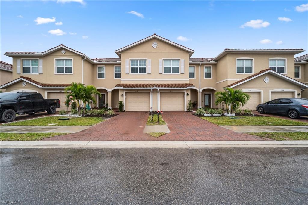 2878 Blossom Way Naples, FL 34120 - Photo 5 of 40 a front view of a house with a yard and garage