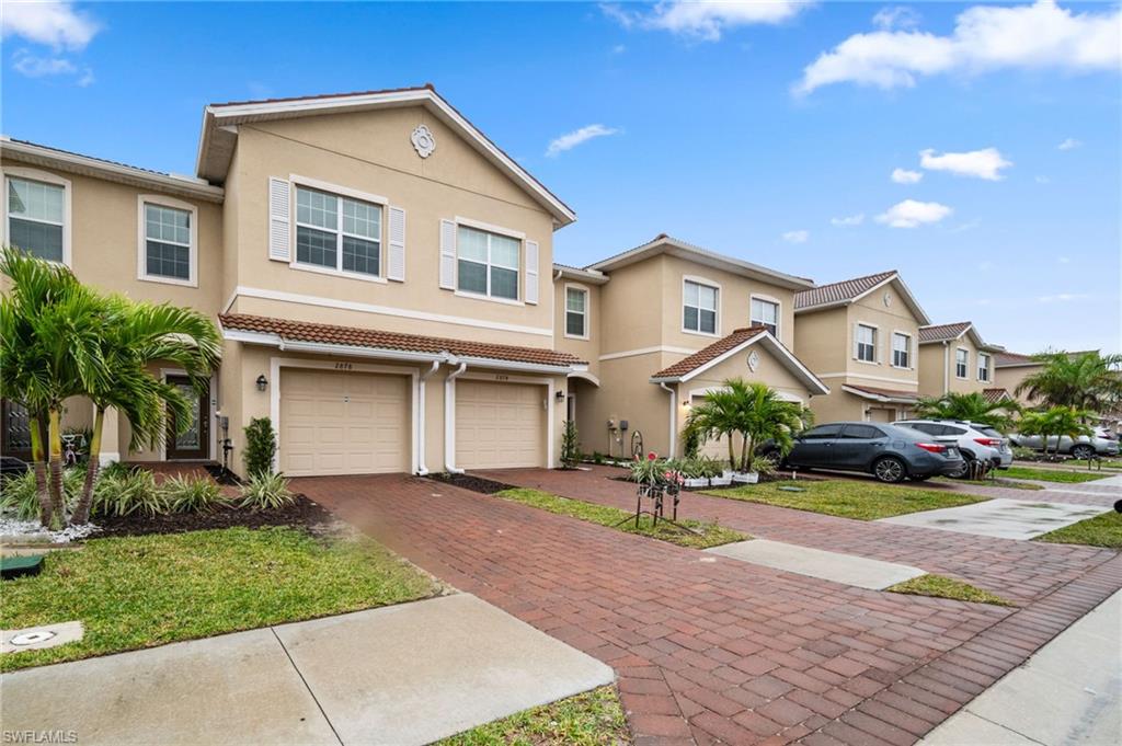 2878 Blossom Way Naples, FL 34120 - Photo 6 of 40 a front view of a house with a yard and garage