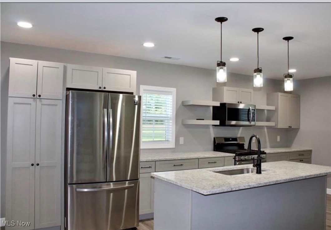 1097 Old River Road Boaz, WV 26187 - Photo 9 of 21 Kitchen with appliances with stainless steel finishes, open shelves, decorative light fixtures, light stone counters, and light wood finished floors