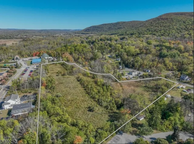 an aerial view of residential houses with outdoor space and trees