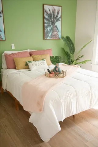 a bedroom with a bed and painting on the wall