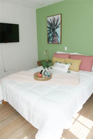 a bedroom with a bed and a flat screen tv