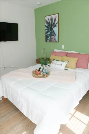 a bedroom with a bed and a flat screen tv